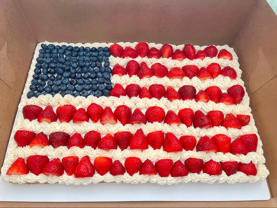 Sheet cake decorated as an American flag with strawberries and blueberries